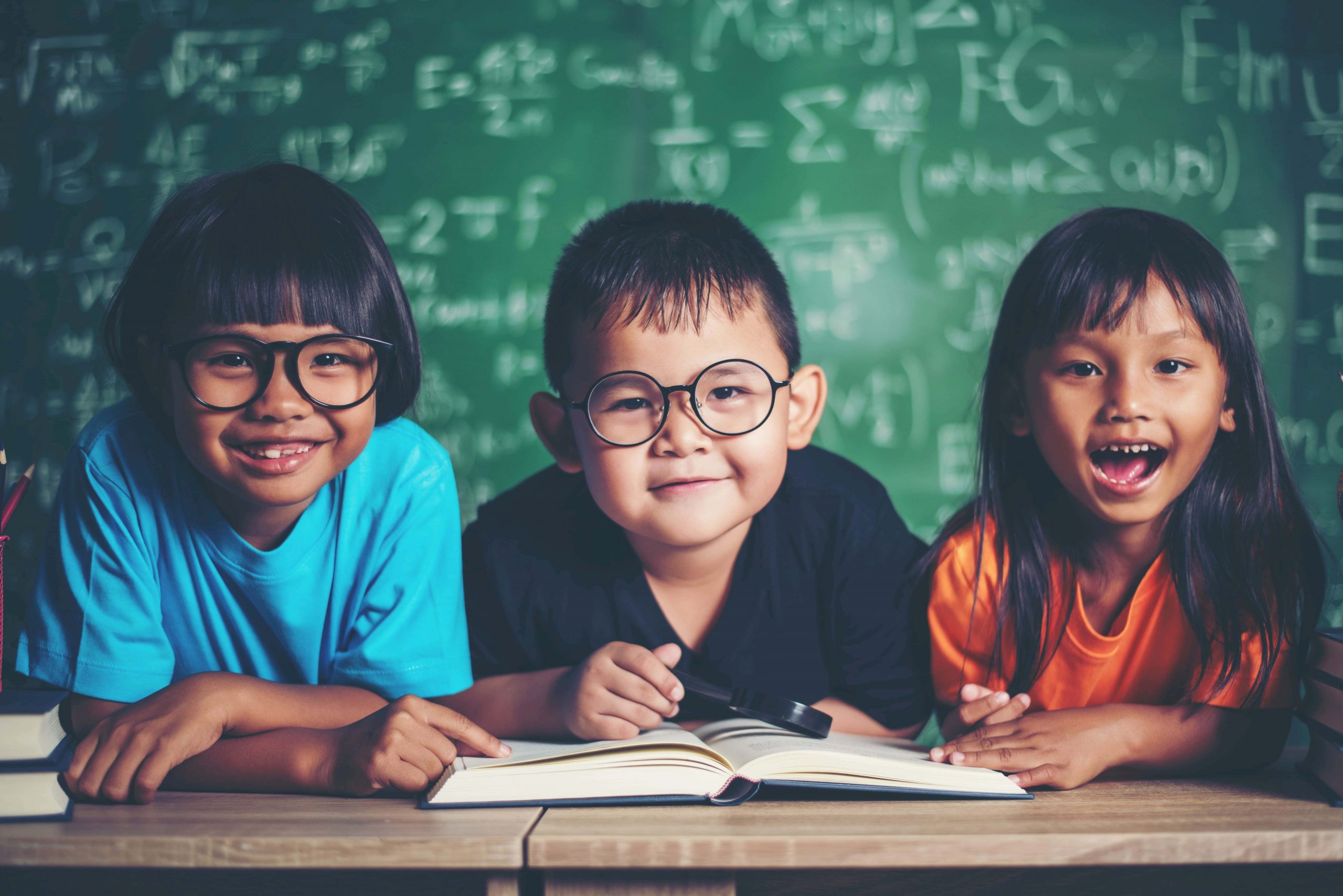 Aula de física particular para ensino fundamental em  Moema, Penha e Pirituba na cidade de São Paulo. O Professor de Física para aulas particulares ensina fórmulas de física no quadro branco, enquanto alunos recebem suporte personalizado. 